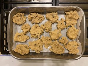 cookie batter globs in pan on a sheet of wax paper
