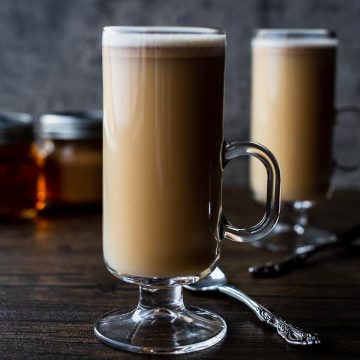 two hot buttered rums in tall glasses on a dark background