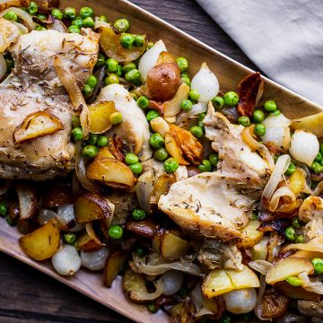 platter of roasted chicken with peas and pearl onions