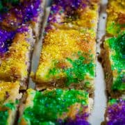bars of cinnamon roll cheesecake with mardi gras colors