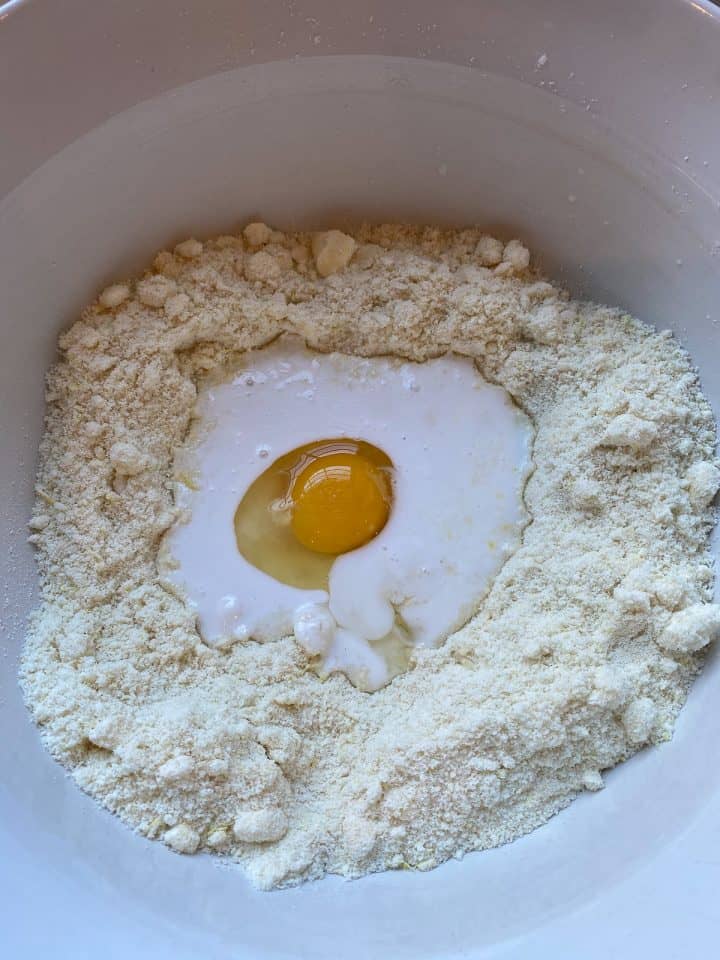 well of dry ingredients with egg and coconut milk