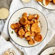 a table of fried zucchini plates with wine and ranch